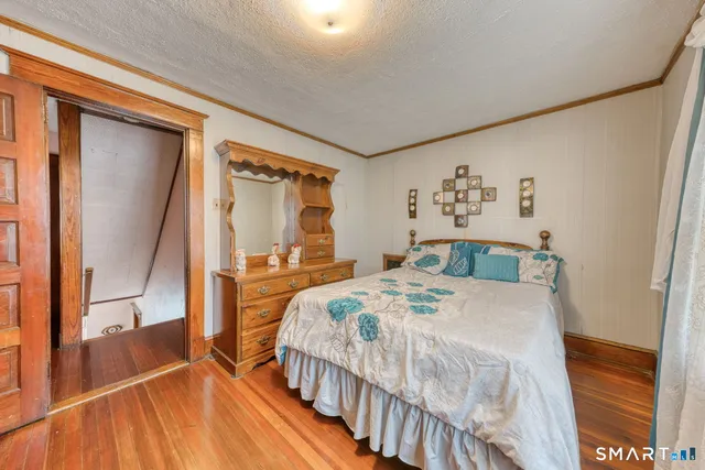 a bedroom with a bed and a large mirror on the dresser