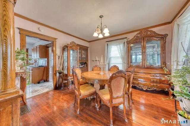 a dining room with furniture a chandelier and wooden floor