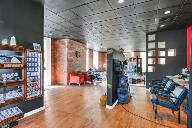 a kitchen with granite countertop stainless steel appliances a refrigerator cabinets and wooden floor