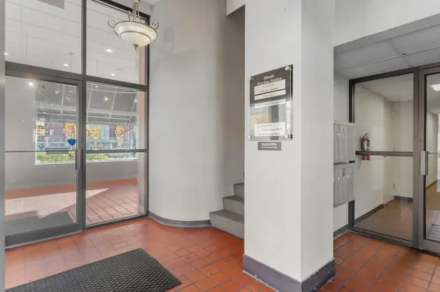 a view of large kitchen with stainless steel appliances wooden floor and large windows