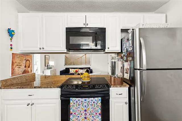 a kitchen with stainless steel appliances granite countertop a refrigerator stove and microwave