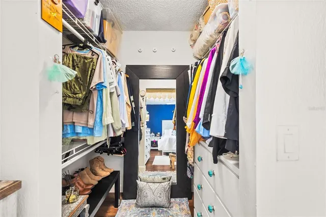 a view of walk in closet with clothes and shoes
