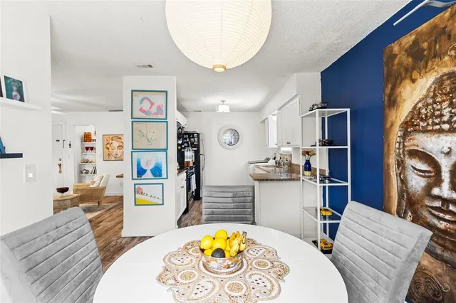 a living room with stainless steel appliances furniture a rug and a view of kitchen