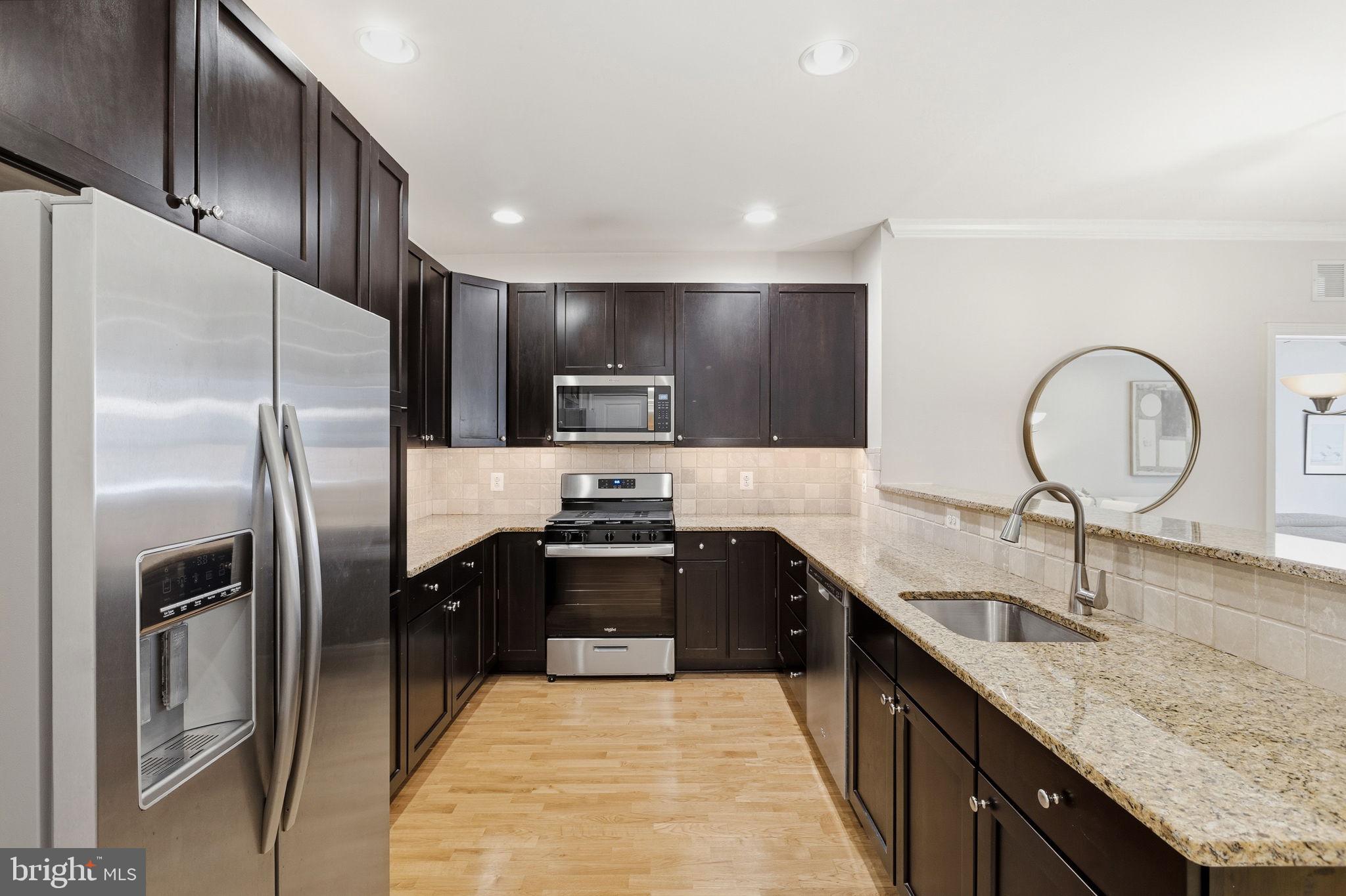 600 Commodore Court, Unit 2604 Philadelphia, PA 19146 - Photo 3 of 33 a large kitchen with stainless steel appliances granite countertop a sink refrigerator and cabinets