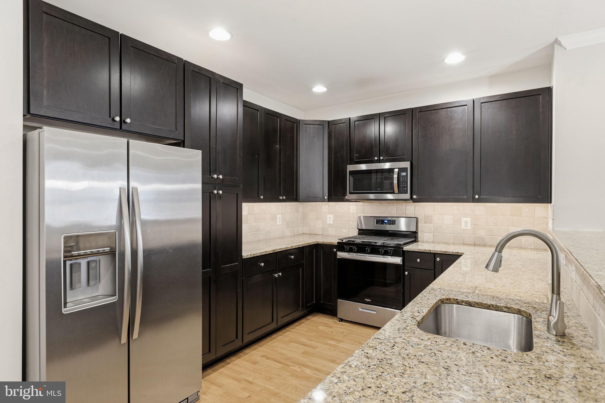 600 Commodore Court, Unit 2604 Philadelphia, PA 19146 - Photo 4 of 33 a kitchen with granite countertop stainless steel appliances cabinets a sink and a refrigerator