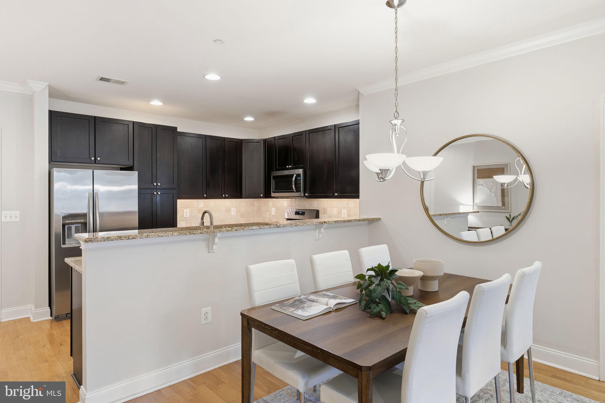 600 Commodore Court, Unit 2604 Philadelphia, PA 19146 - Photo 6 of 33 a kitchen with kitchen island a stove a table and chairs
