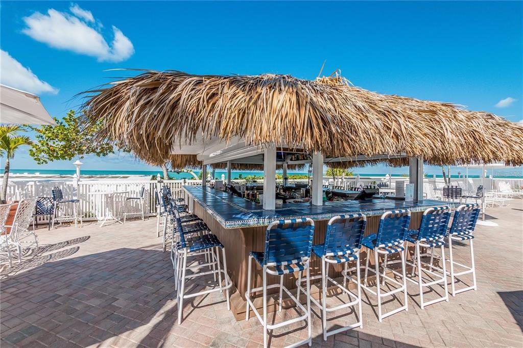 5000 Gasparilla Road, Unit DC107 Boca Grande, FL 33921 - Photo 22 of 30 a view of a patio with table and chairs under an umbrella with a patio