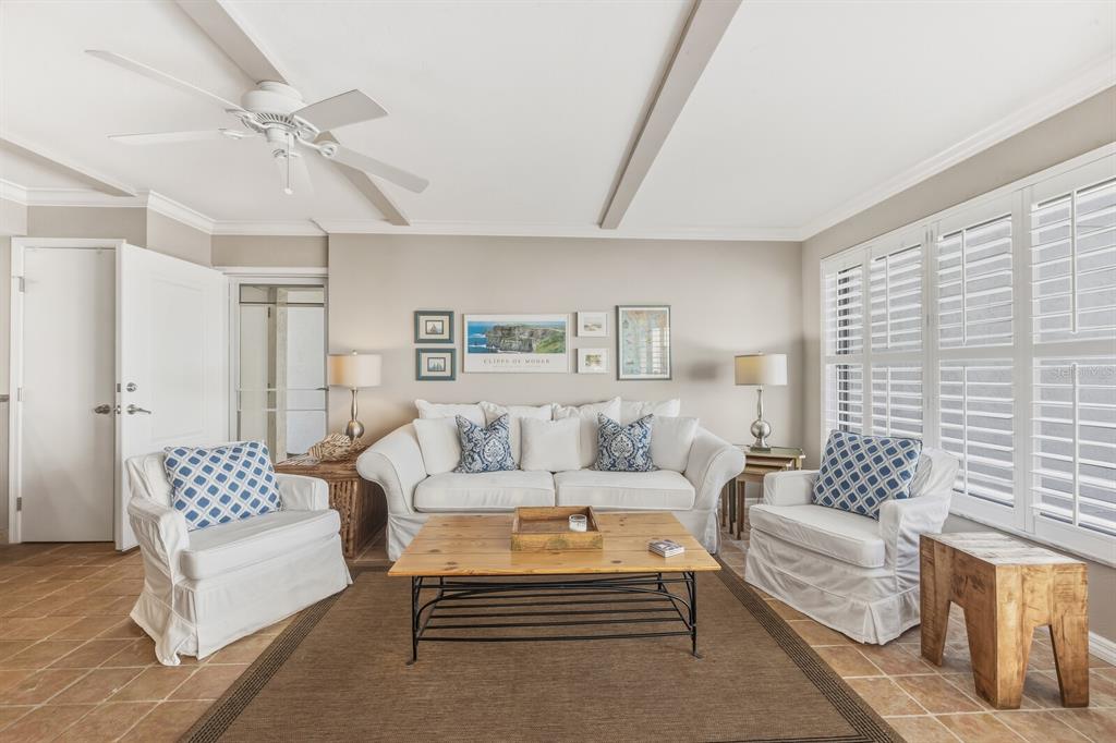5000 Gasparilla Road, Unit DC107 Boca Grande, FL 33921 - Photo 3 of 30 a living room with furniture a rug and a chandelier
