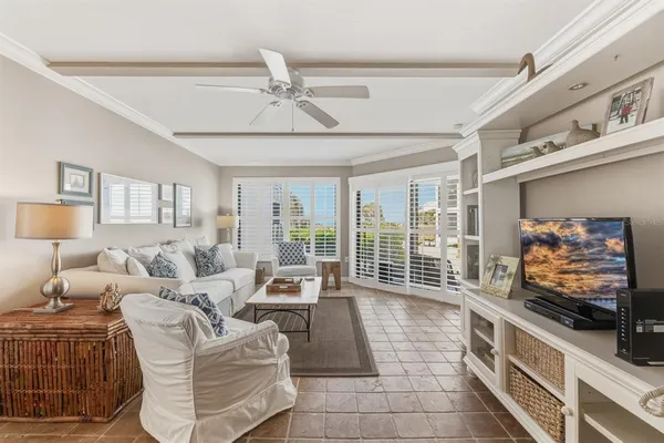 a living room with furniture a flat screen tv and a floor to ceiling window
