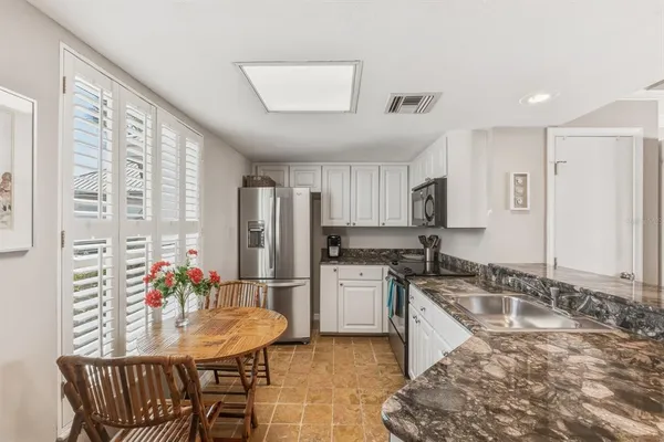 a kitchen with granite countertop a sink cabinets and stainless steel appliances