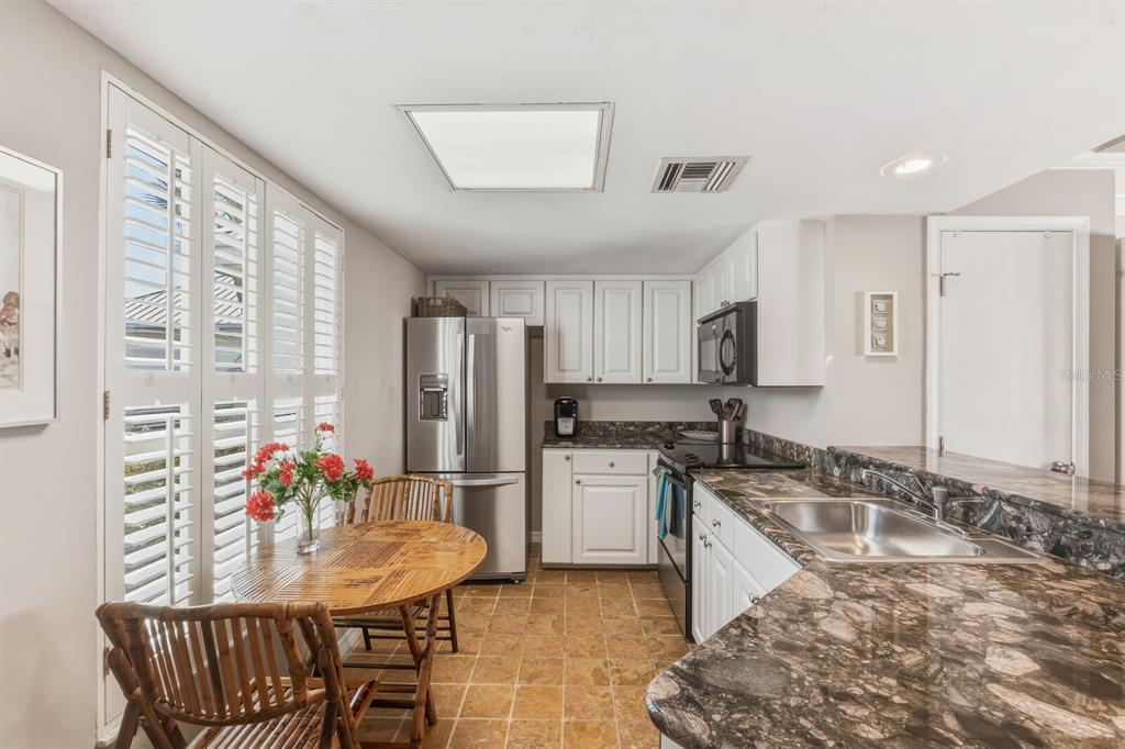 5000 Gasparilla Road, Unit DC107 Boca Grande, FL 33921 - Photo 7 of 30 a kitchen with granite countertop a sink cabinets and stainless steel appliances