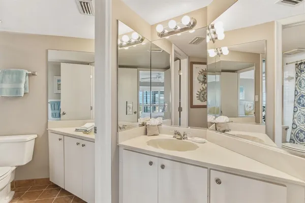 a bathroom with a sink a toilet and a mirror