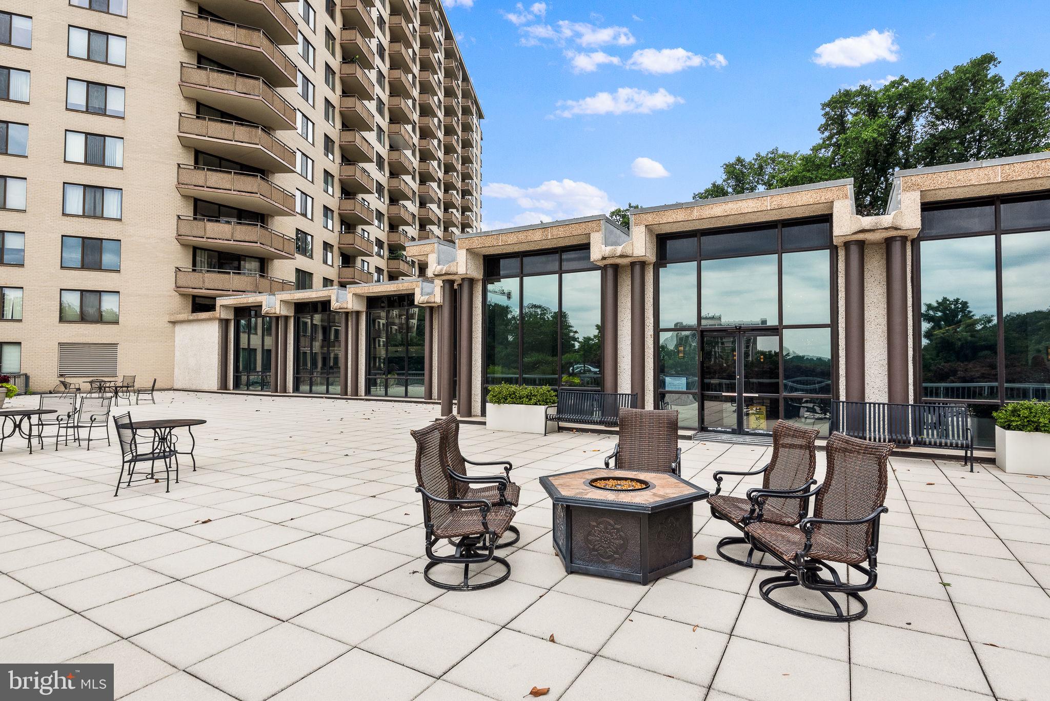 5225 Pooks Hill Road, Unit 1824N Bethesda, MD 20814 - Photo 15 of 50 a view of a patio with dining table and chairs with wooden floor and fence