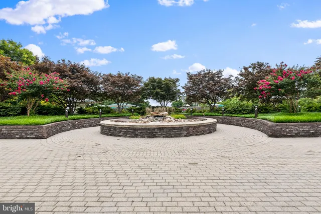a view of a garden with a bench in front of the house