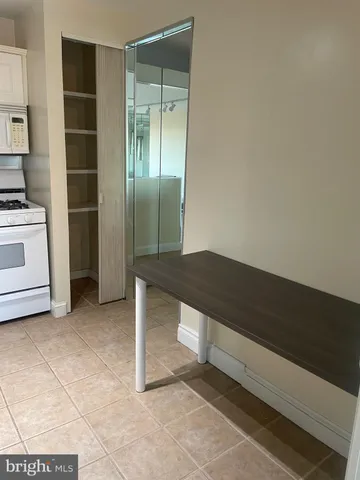 a view of kitchen with a sink and dishwasher a oven with white cabinets