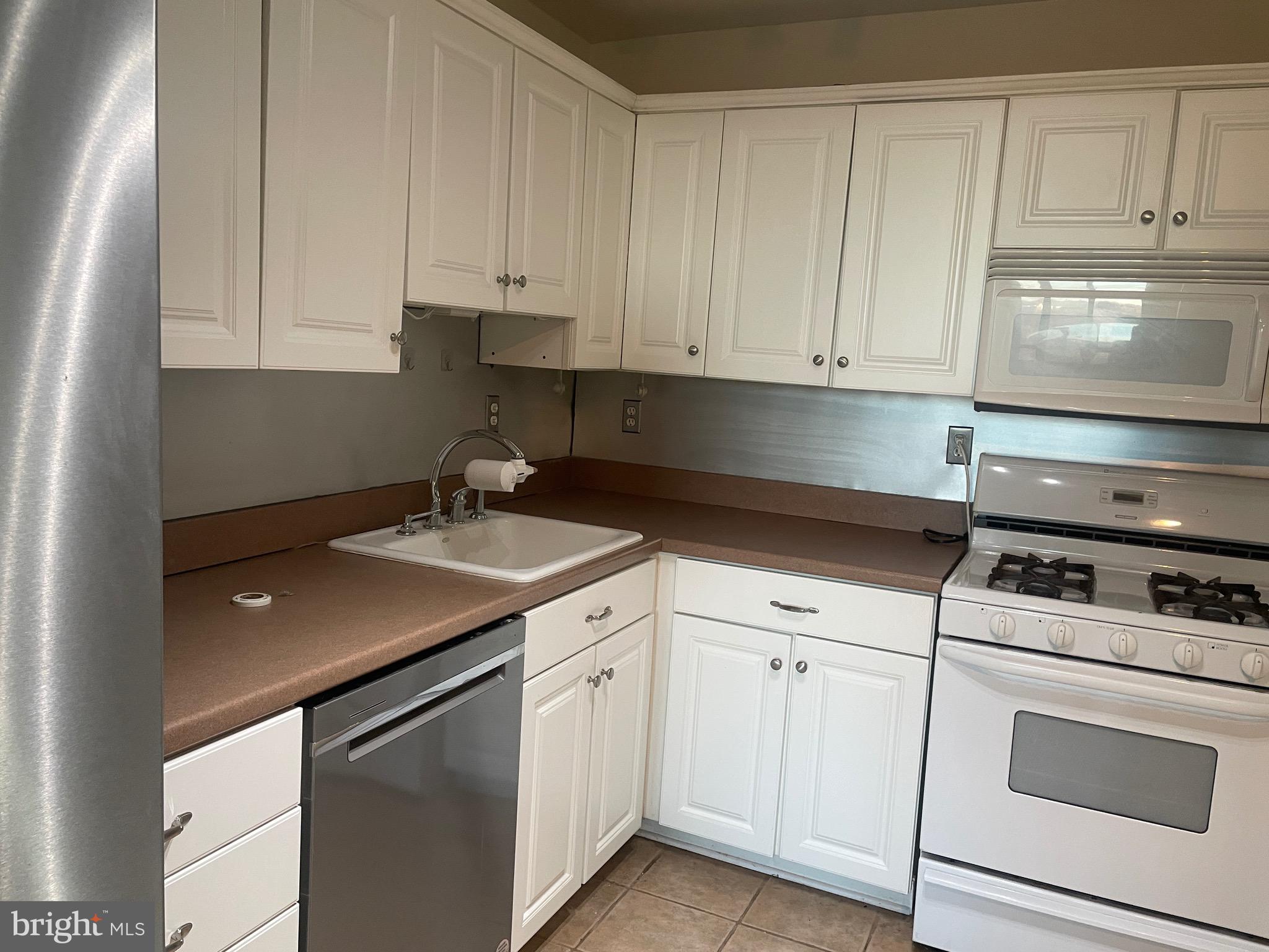 5225 Pooks Hill Road, Unit 1824N Bethesda, MD 20814 - Photo 9 of 50 a kitchen with white cabinets and white appliances