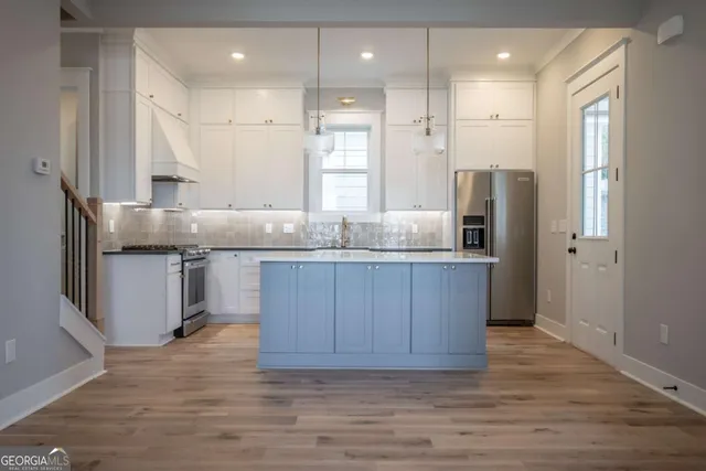 a kitchen with kitchen island granite countertop wooden cabinets and a refrigerator