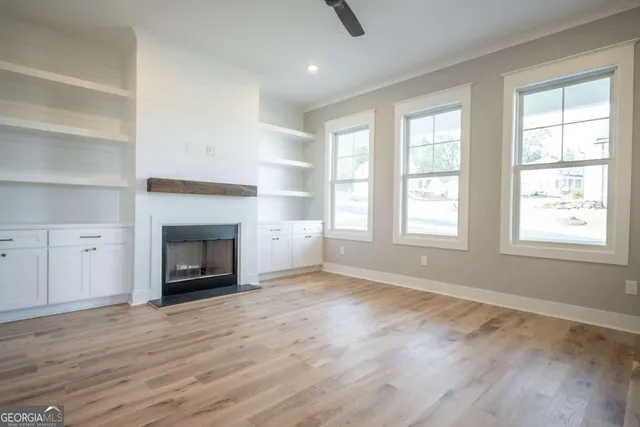 wooden floor fireplace and windows in an empty room