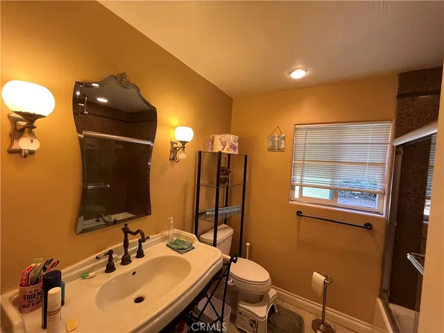 a bathroom with a sink mirror and toilet