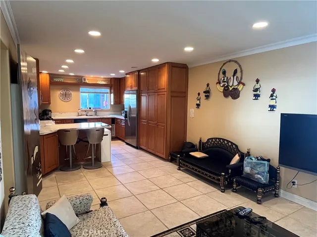 a kitchen with stainless steel appliances kitchen island granite countertop a refrigerator and a stove top oven