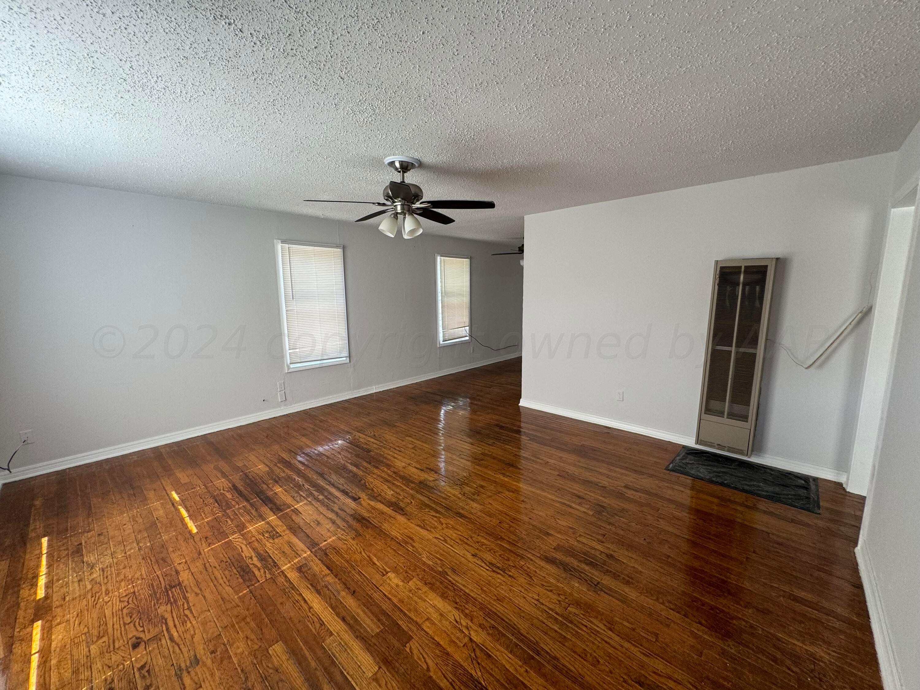4119 Parker Street Amarillo, TX 79110 - Photo 3 of 9 a view of empty room with wooden floor and fan