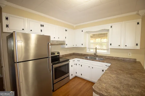 a kitchen with a refrigerator sink and cabinets