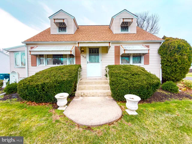 a front view of a house with a yard and trees