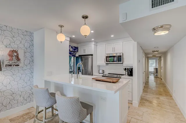 a kitchen with stainless steel appliances kitchen island granite countertop a sink and cabinets