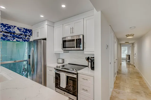 a kitchen with stainless steel appliances granite countertop a stove a microwave and a refrigerator