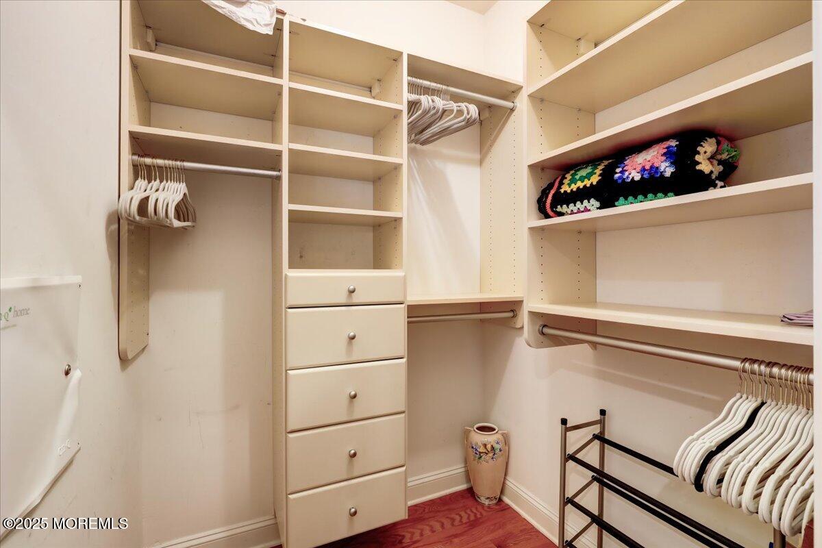 a view of walk in closet with clothes and shoes