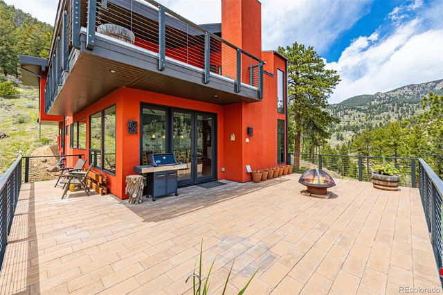 a view of roof deck with chair and tables