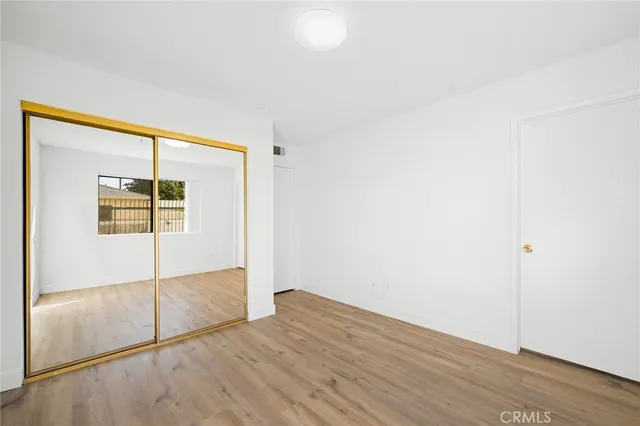 an empty room with wooden floor and cabinet
