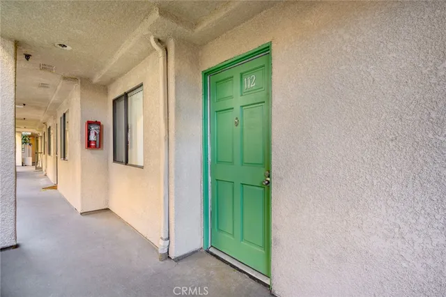 a view of a hallway with bathroom and a green closet