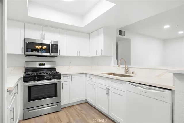 a kitchen with cabinets appliances a sink and a counter top space