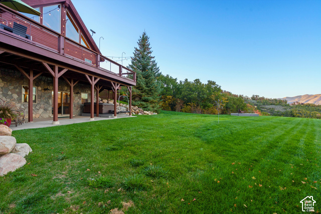 5878 Snowbasin Road Huntsville, UT 84317 - Photo 55 of 90 Stone exterior with a full-length covered patio, expansive lawn, and mature trees