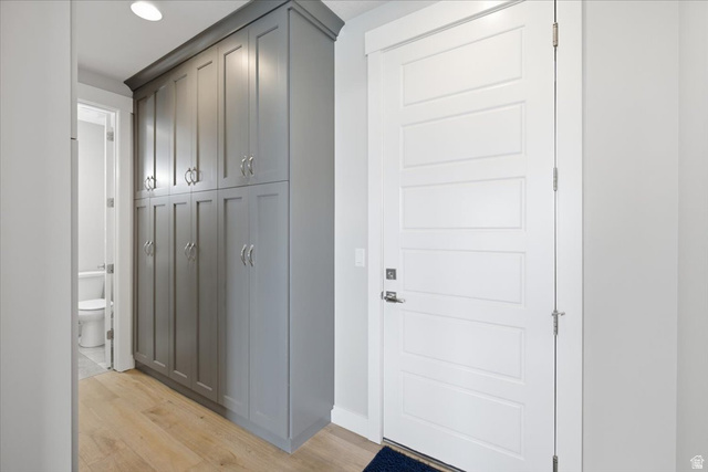21 Pier Place Tooele, UT 84074 - Photo 27 of 112 Entryway with durable wood-finish flooring, featuring a paneled white door with modern hardware, and extensive built-in cabinetry with crown molding and polished chrome pulls