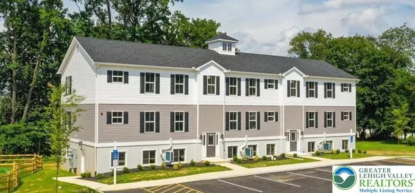 a front view of a residential apartment building with a yard