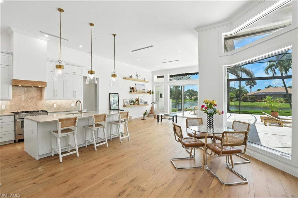 581 Wedgewood Way Naples, FL 34119 - Photo 11 of 33 a living room with furniture a wooden floor and a floor to ceiling window