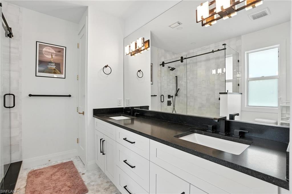 581 Wedgewood Way Naples, FL 34119 - Photo 20 of 33 a bathroom with a granite countertop sink a toilet a shower and a mirror