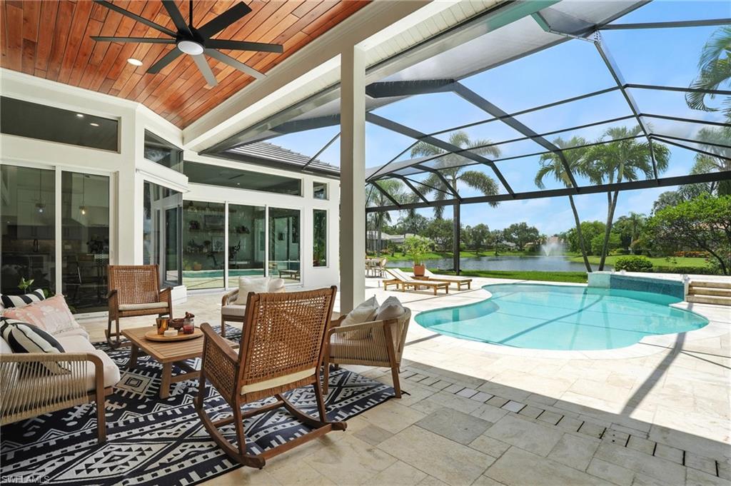 581 Wedgewood Way Naples, FL 34119 - Photo 2 of 33 a view of a patio with a table and chairs under an umbrella