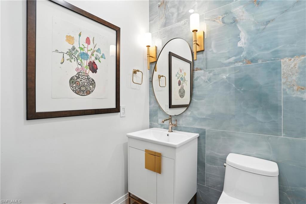 581 Wedgewood Way Naples, FL 34119 - Photo 21 of 33 a bathroom with a toilet sink and mirror