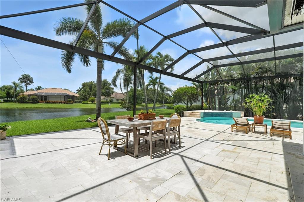 581 Wedgewood Way Naples, FL 34119 - Photo 27 of 33 a view of a patio with a table chairs and a yard