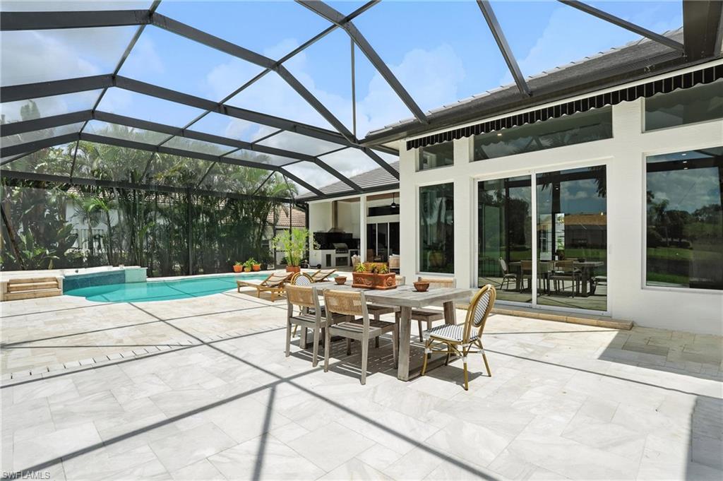 581 Wedgewood Way Naples, FL 34119 - Photo 28 of 33 a view of a patio with a dining table and chairs