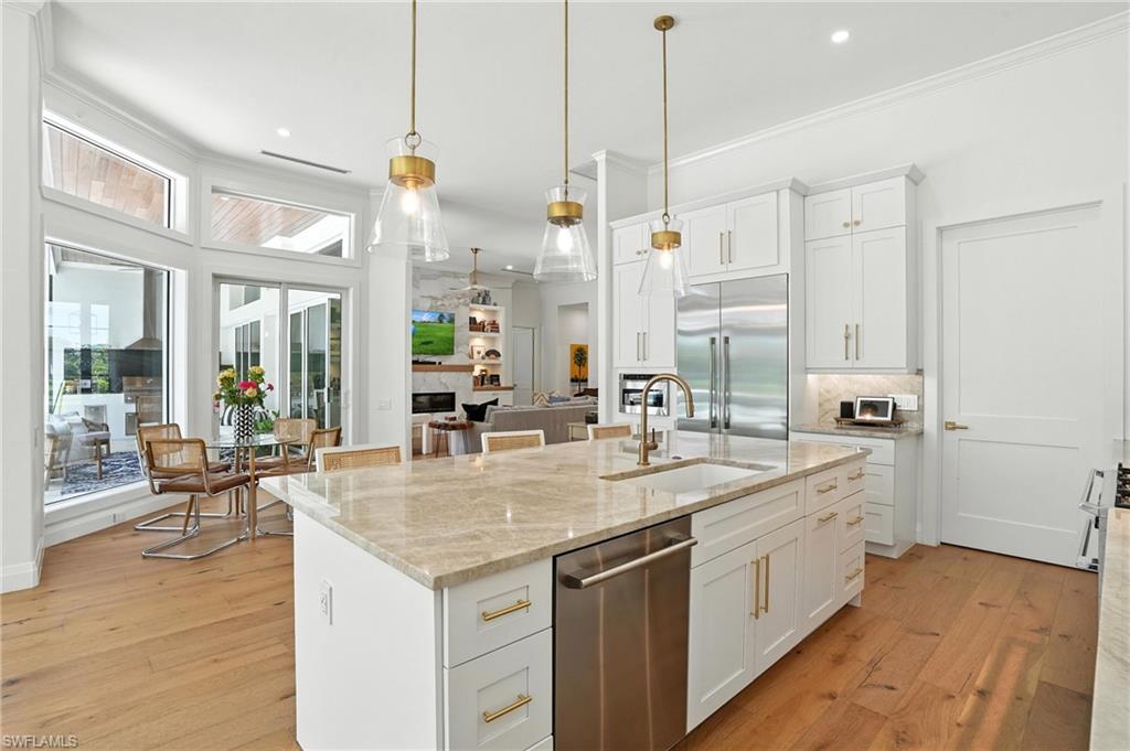 581 Wedgewood Way Naples, FL 34119 - Photo 5 of 33 a kitchen with sink stove and wooden floor