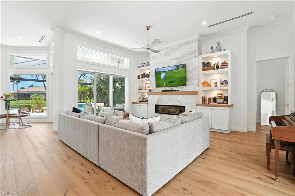 581 Wedgewood Way Naples, FL 34119 - Photo 6 of 33 a living room with furniture a flat screen tv and a fireplace