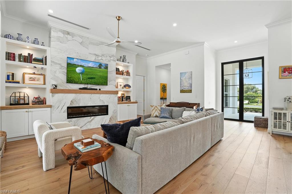 581 Wedgewood Way Naples, FL 34119 - Photo 7 of 33 a living room with furniture a flat screen tv and a fireplace