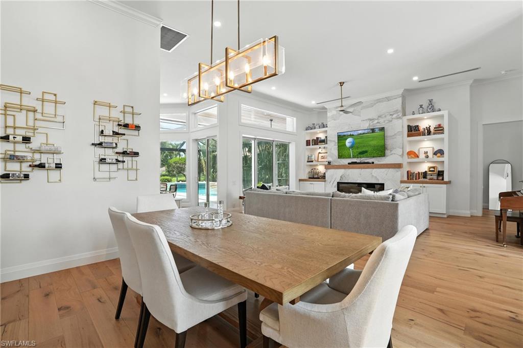581 Wedgewood Way Naples, FL 34119 - Photo 9 of 33 a view of a dining room with furniture a kitchen and chandelier