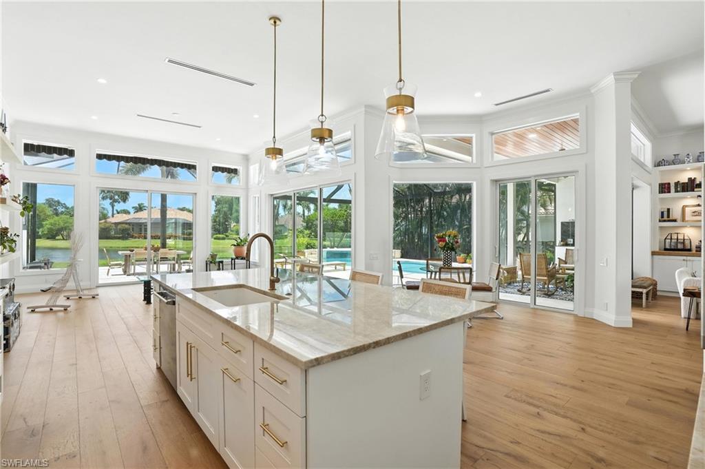 581 Wedgewood Way Naples, FL 34119 - Photo 10 of 33 a large kitchen with kitchen island a large window a sink and living room view