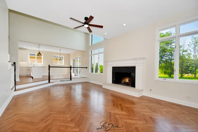 a kitchen with stainless steel appliances granite countertop a sink a oven a refrigerator and white cabinets with wooden floor