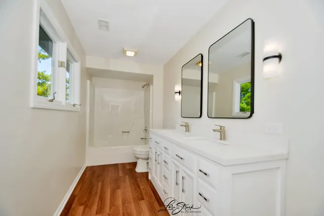 a bathroom with a granite countertop toilet sink and mirror